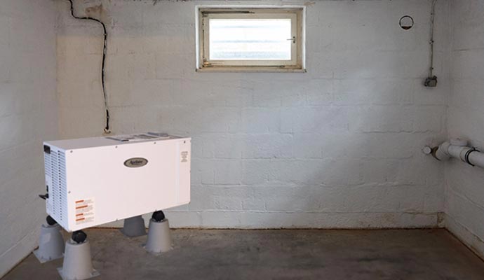 Basement dehumidifier installed on support blocks near a wall