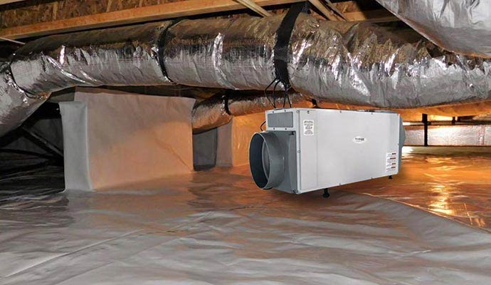 A high-capacity crawl space dehumidifier suspended from floor joists above a professional white vapor barrier encapsulation