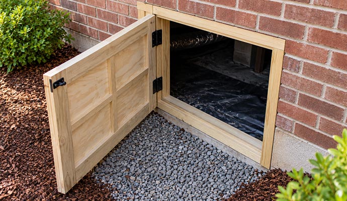 Hinged crawl space access door on brick foundation