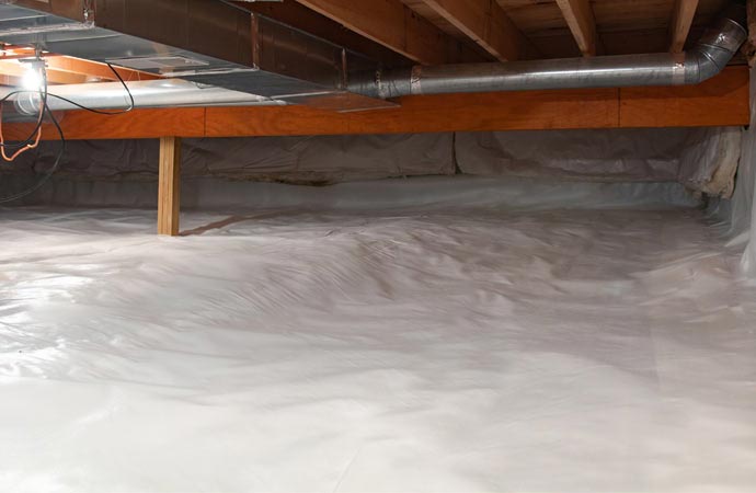 Installation of encapsulation for waterproofing in crawl space.