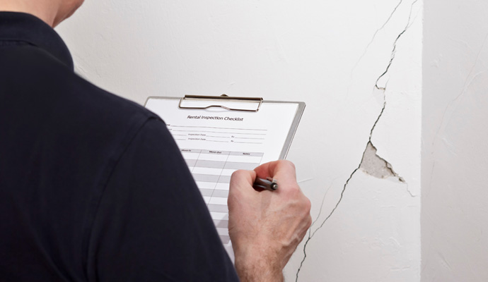 a man inspecting wall crack