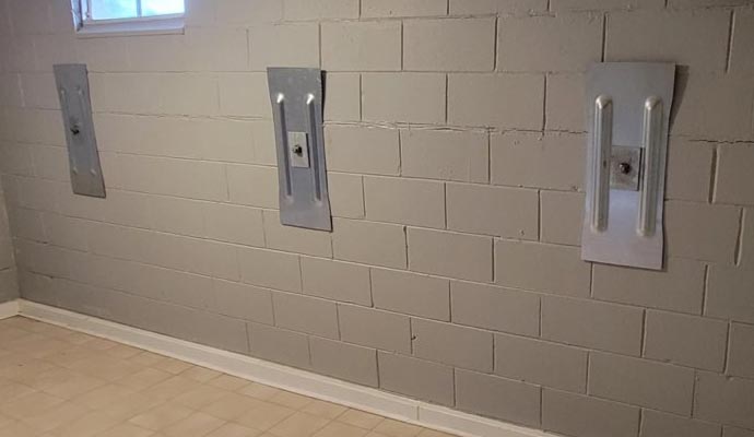 Metal anchor plate on the basement wall