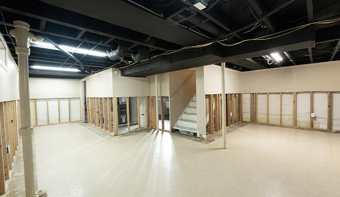 Unfinished basement undergoing preparation for professional waterproofing